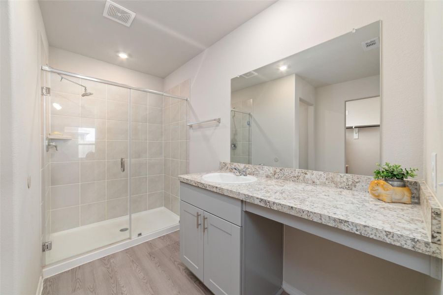 Well-appointed bathroom with a spacious vanity and glass-enclosed shower, creating a light and open atmosphere.