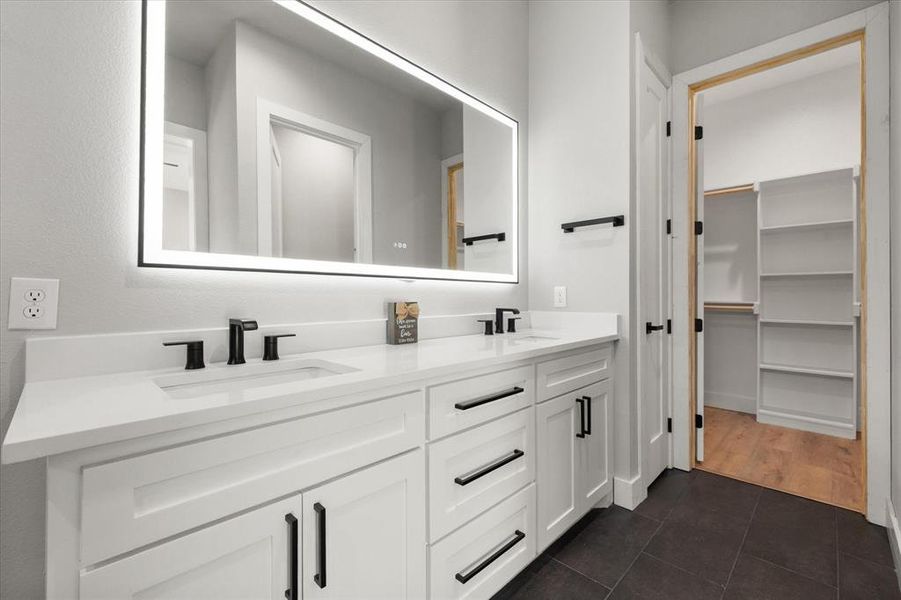 Full bathroom featuring double vanity and dark tile patterned floors Full bathroom featuring double vanity and dark tile patterned floors