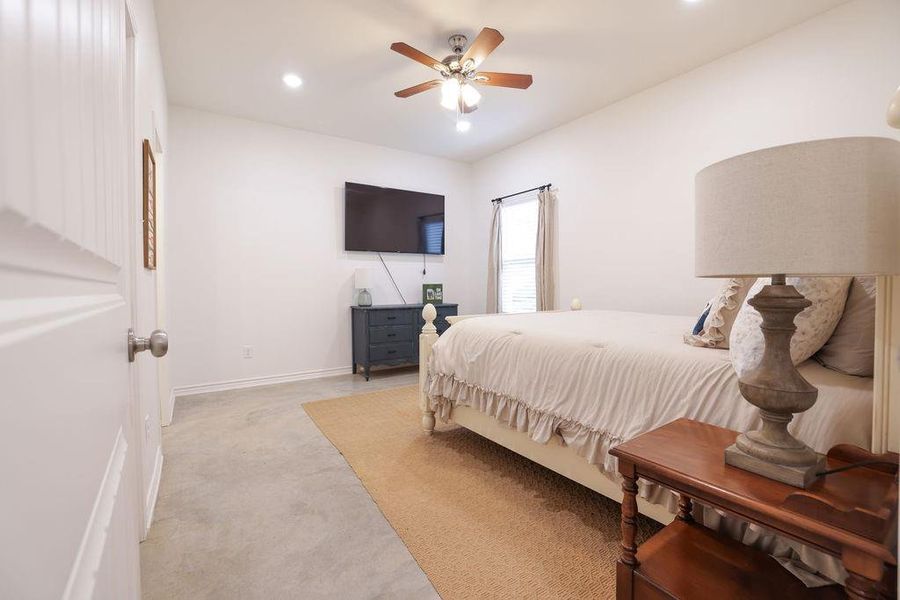 Bedroom featuring light carpet, recessed lighting, and a ceiling fan