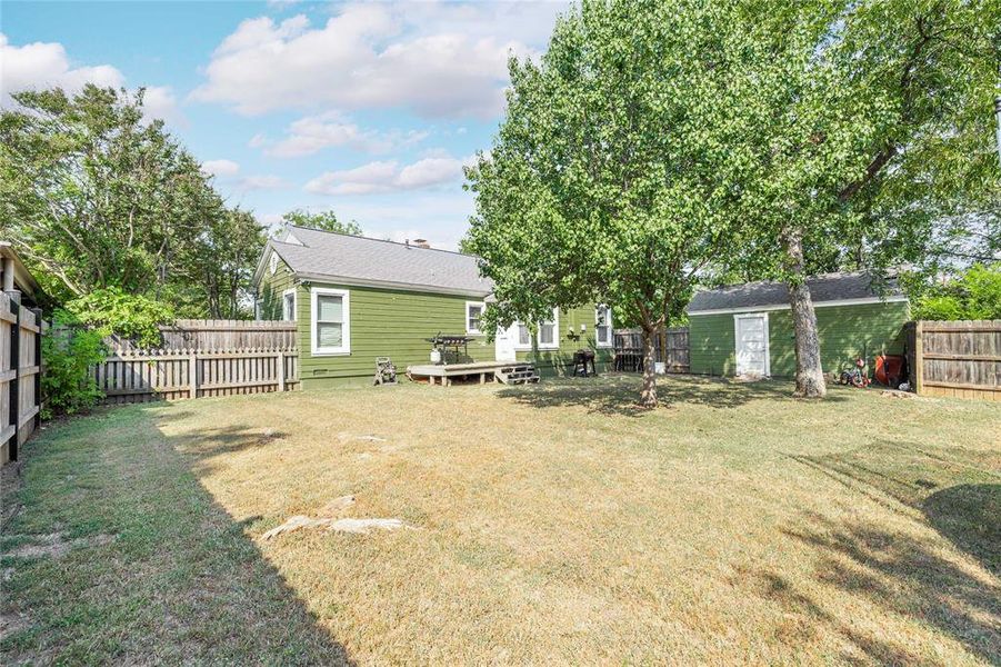 Fenced backyard with a wooden deck and an outdoor structure Fenced backyard with a wooden deck and an outdoor structure
