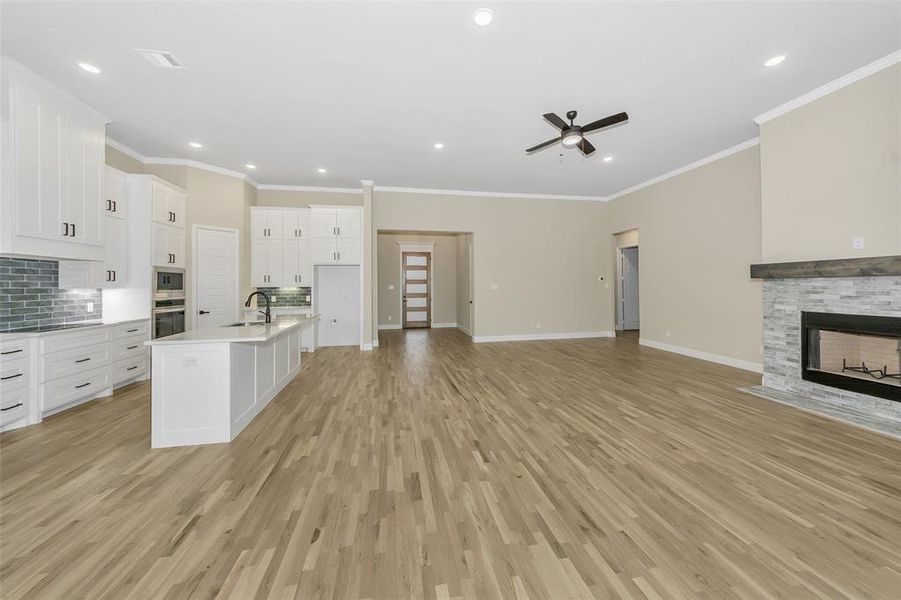 Kitchen featuring crown molding, white cabinetry, sink, and light hardwood / wood-style flooring