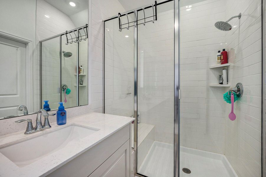 Glass-enclosed walk-in shower with updated tile and fixtures. Glass-enclosed walk-in shower with updated tile and fixtures.