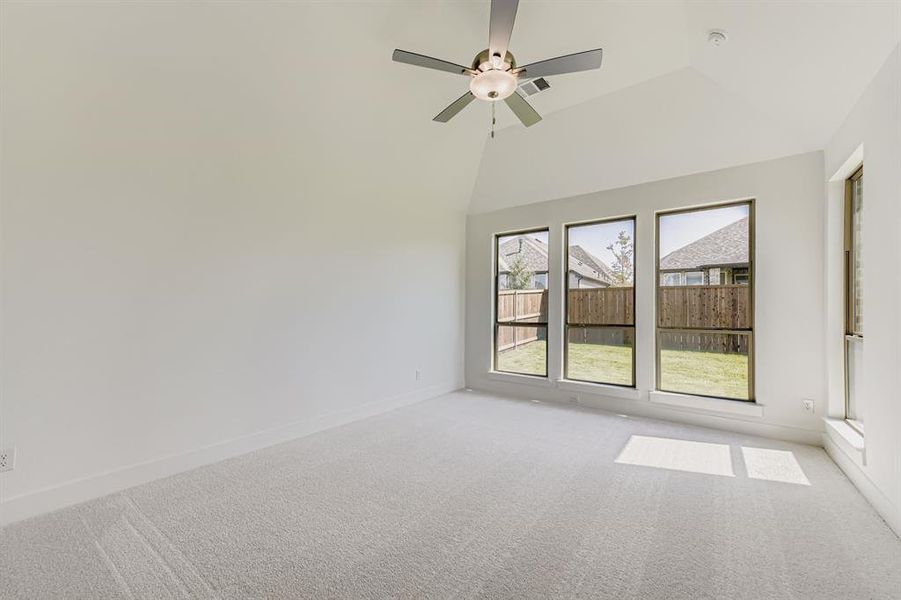 Unfurnished room with carpet floors, ceiling fan, and a high ceiling Unfurnished room with carpet floors, ceiling fan, and a high ceiling