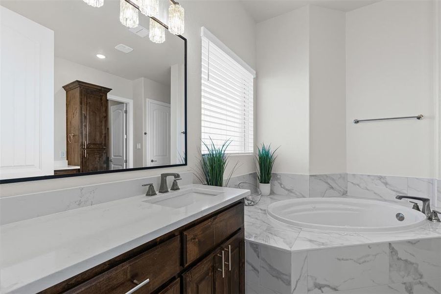 Primary Bathroom featuring vanity and a bath Primary Bathroom featuring vanity and a bath