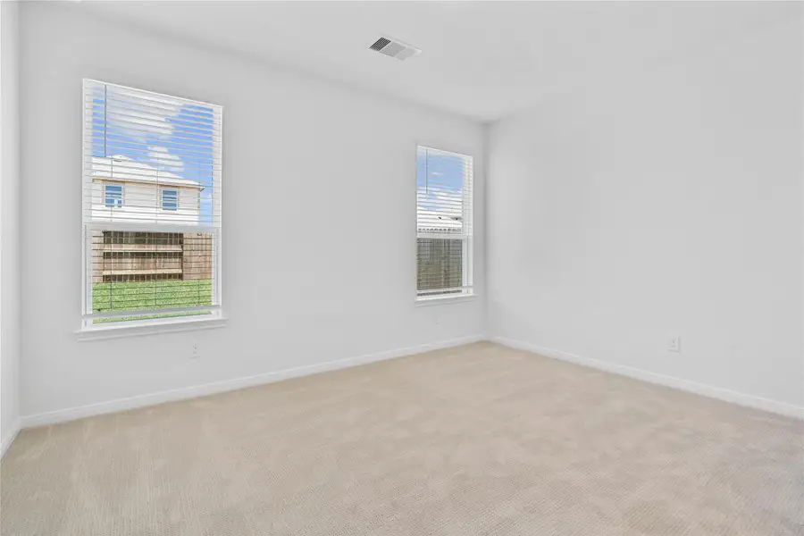 Relax and unwind after a long day in this impressive primary suite! This generously sized room offers carpet floor, warm-toned paint, high ceilings, and large windows with blinds for added comfort and tranquility. Relax and unwind after a long day in this impressive primary suite! This generously sized room offers carpet floor, warm-toned paint, high ceilings, and large windows with blinds for added comfort and tranquility.