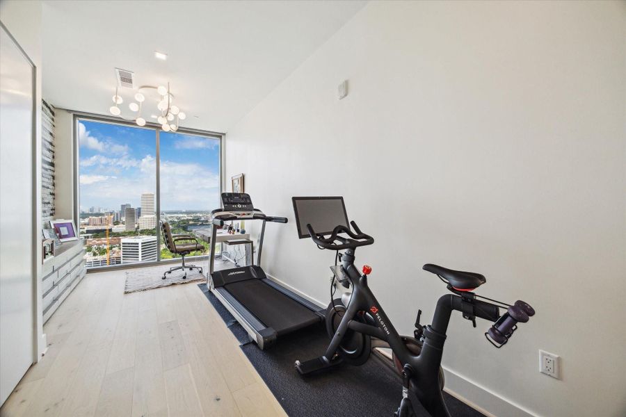 The other secondary bedroom which is currently used as an office and workout space.  Note the creative wallcovering and lighting by Nina Magon.