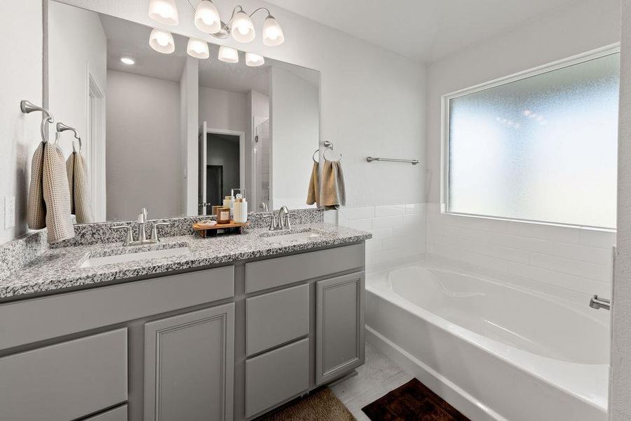 Bathroom with a garden tub, double vanity, and a stall shower