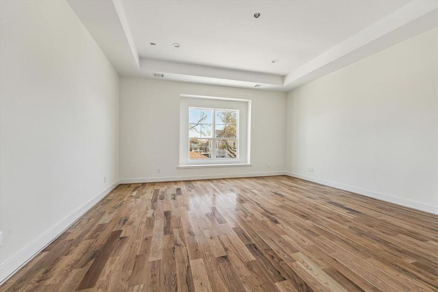 16x13 Primary bedroom with window seat, tray ceiling and plenty of room for a sitting area within the bedroom.