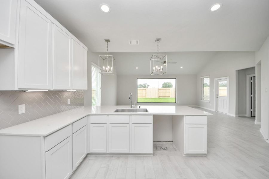 The open concept effortlessly connects the kitchen to the expansive family room, forming a perfect hub for gatherings. This seamless flow creates an inviting space where cooking and socializing come together harmoniously. Sample photo of completed home with similar floor plan. Actual colors and selections may vary. The open concept effortlessly connects the kitchen to the expansive family room, forming a perfect hub for gatherings. This seamless flow creates an inviting space where cooking and socializing come together harmoniously. Sample photo of completed home with similar floor plan. Actual colors and selections may vary.