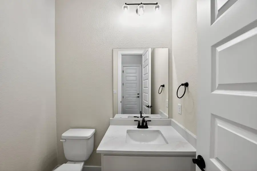Half bath with a textured wall and vanity Half bath with a textured wall and vanity