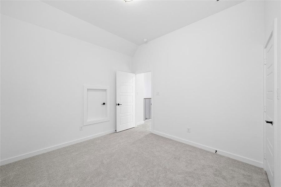 Carpeted room with white walls, a white paneled door with black hardware, and an access panel