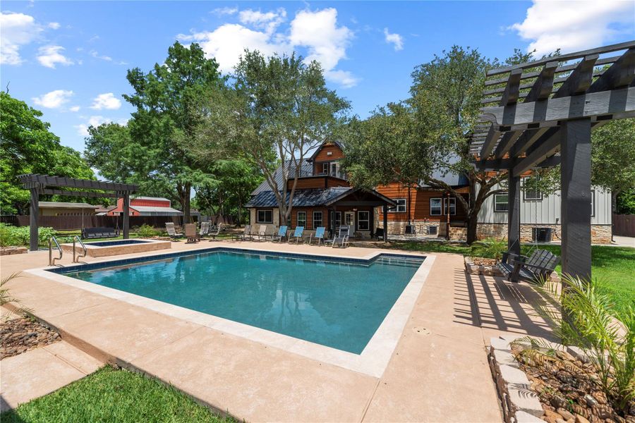 Resort-style outdoor living designed for elevated entertaining, featuring a sparkling pool, expansive patio spaces, and a private retreat surrounded by mature trees and timeless architecture.