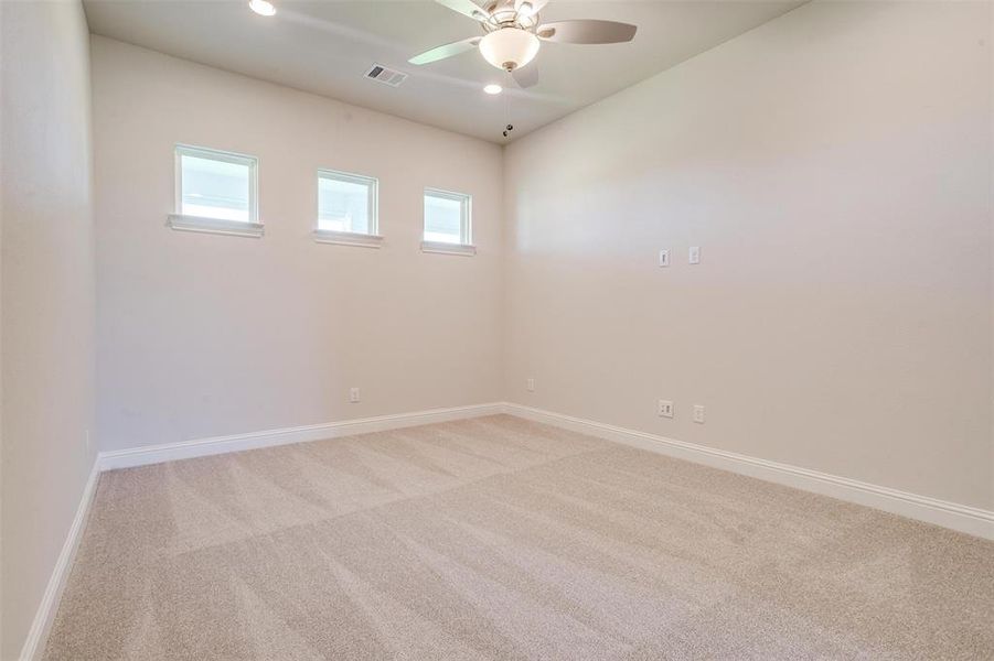 Spare room with ceiling fan and light colored carpet