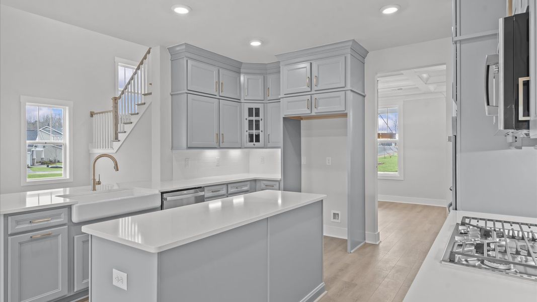 Highly skilled craftsmanship shines in this modern kitchen with pendant lighting and a central island focal point