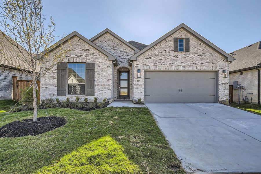 View of front of home featuring a front yard and a garage