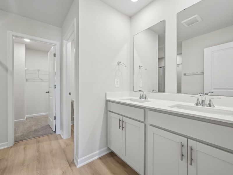 Relax in the spacious primary suite featuring an ensuite bath with dual sinks and a walk-in closet.
