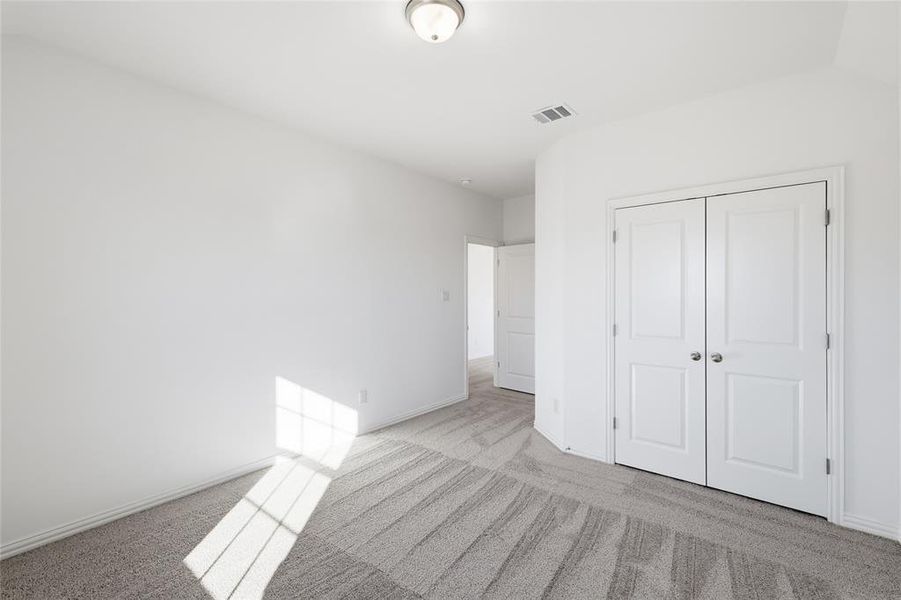 Neutral-toned room featuring a semi-flush ceiling light, white walls, and gray patterned carpet