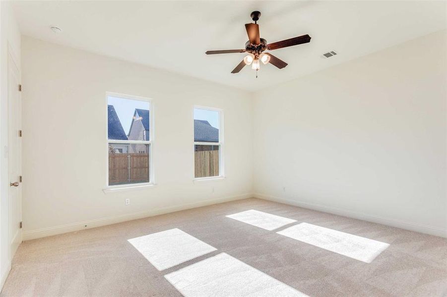 Carpeted spare room featuring ceiling fan