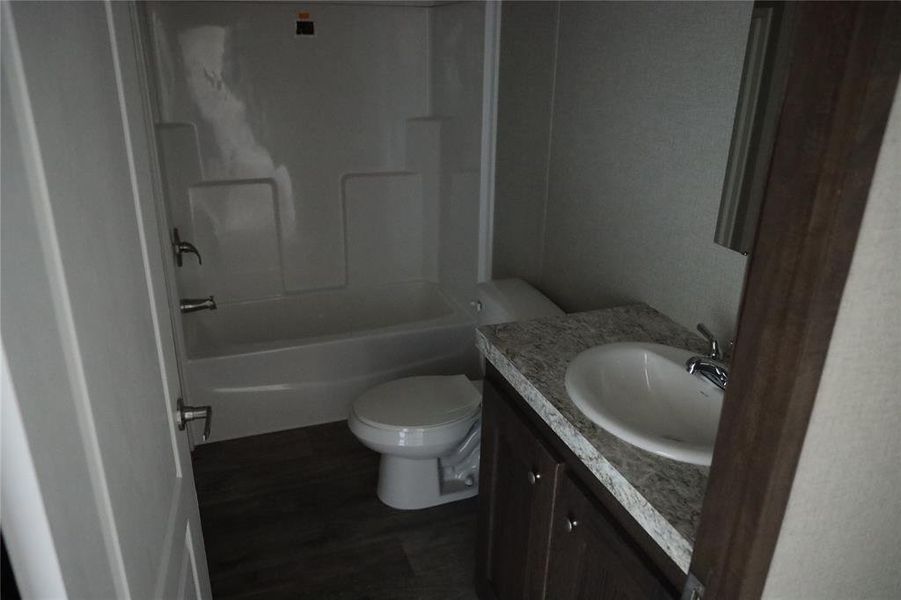 Full bathroom featuring vanity, toilet, shower / bathing tub combination, and hardwood / wood-style flooring