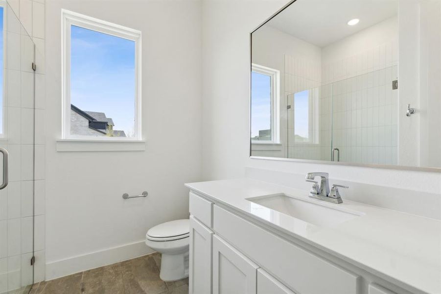 Bathroom featuring a white vanity with an integrated sink, polished chrome faucet, and a large frameless mirror Bathroom featuring a white vanity with an integrated sink, polished chrome faucet, and a large frameless mirror