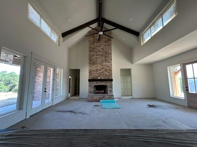 Vaulted ceiling with exposed wood beams and a large ceiling fan