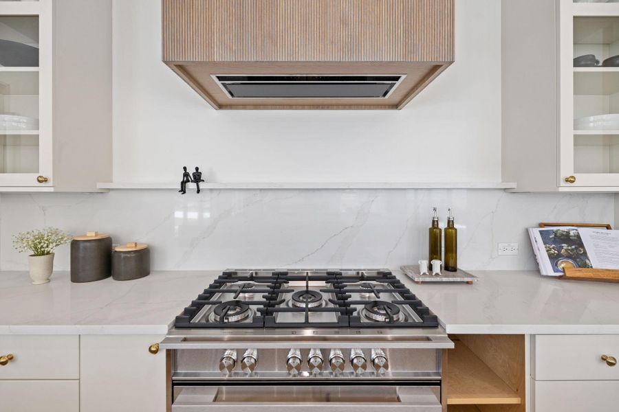 Kitchen with glass insert cabinets, tasteful backsplash, and range hood Kitchen with glass insert cabinets, tasteful backsplash, and range hood