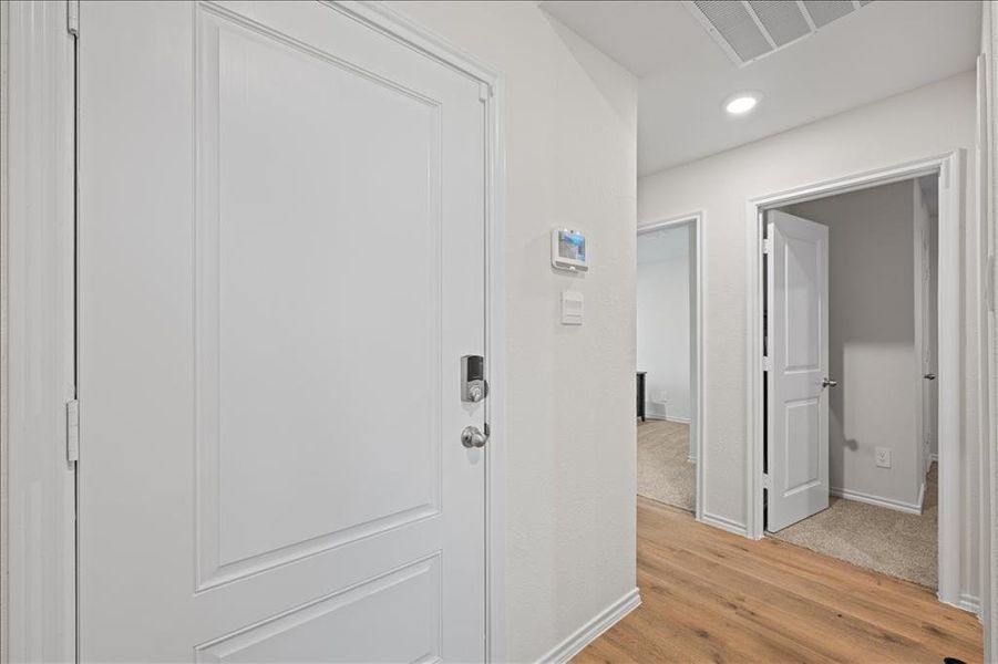 Hallway with light wood-style flooring and recessed lighting Hallway with light wood-style flooring and recessed lighting