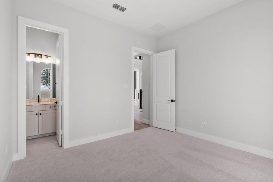 The secondary 1st floor bedroom includes it's own full bath.