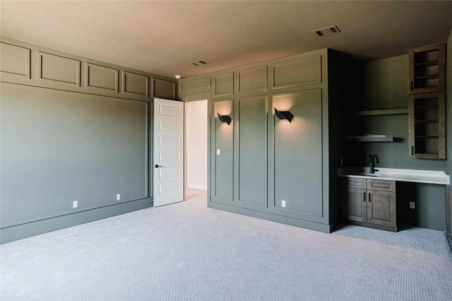 Unfurnished bedroom with light colored carpet and a sink