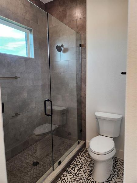 Bathroom featuring a shower stall and tile patterned floors Bathroom featuring a shower stall and tile patterned floors