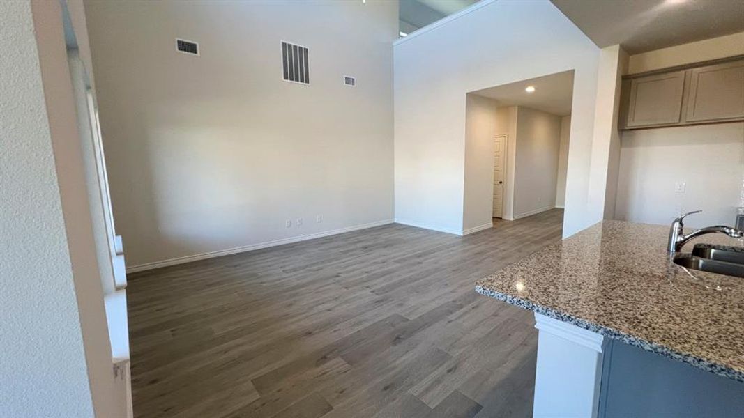 Unfurnished dining area featuring dark wood finished floors and a towering ceiling