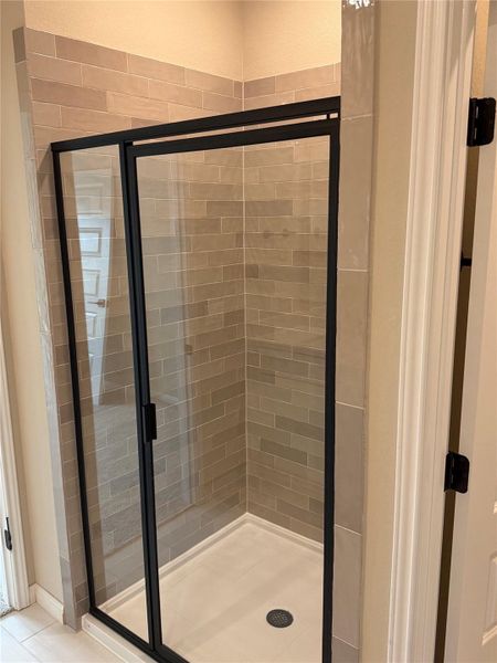 Bathroom featuring a stall shower and light tile patterned flooring