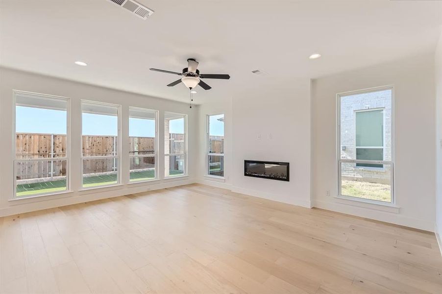 Unfurnished living room featuring light wood-type flooring and ceiling fan