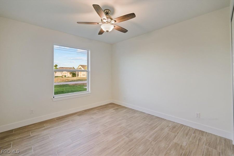 Unfurnished room with wood tiled floors and a ceiling fan