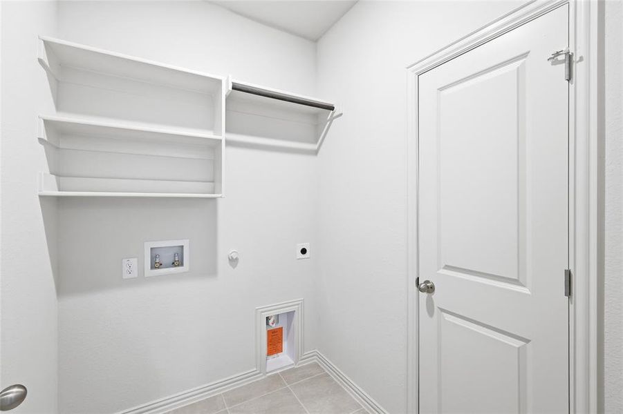 Washroom with light tile patterned flooring, electric dryer hookup, gas dryer hookup, and washer hookup