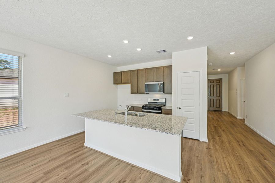 Beyond the hallway to the secondary bedrooms/bathroom, you are ushered into this open concept living space.