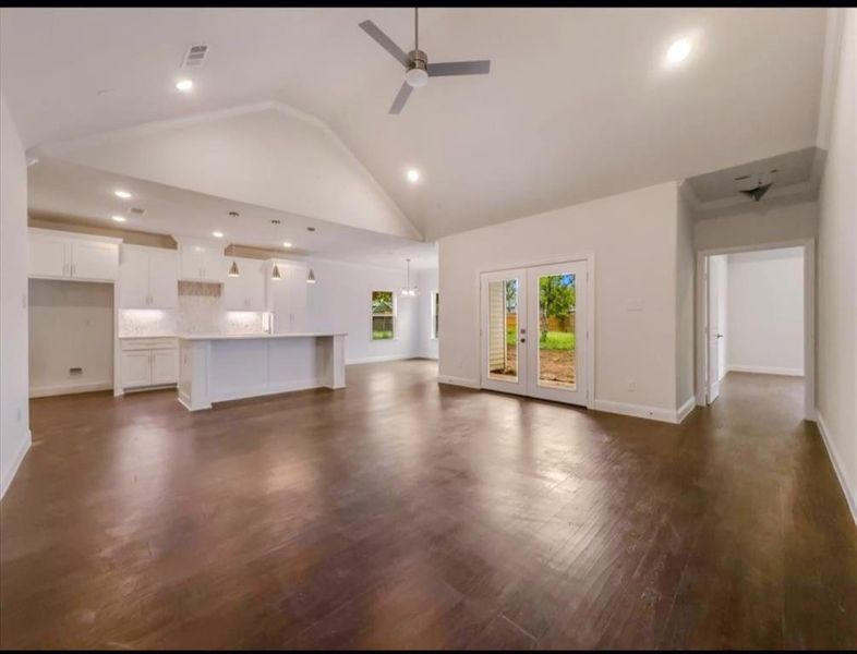 Unfurnished living room featuring recessed lighting, ceiling fan, high vaulted ceiling, and dark wood-type flooring Unfurnished living room featuring recessed lighting, ceiling fan, high vaulted ceiling, and dark wood-type flooring
