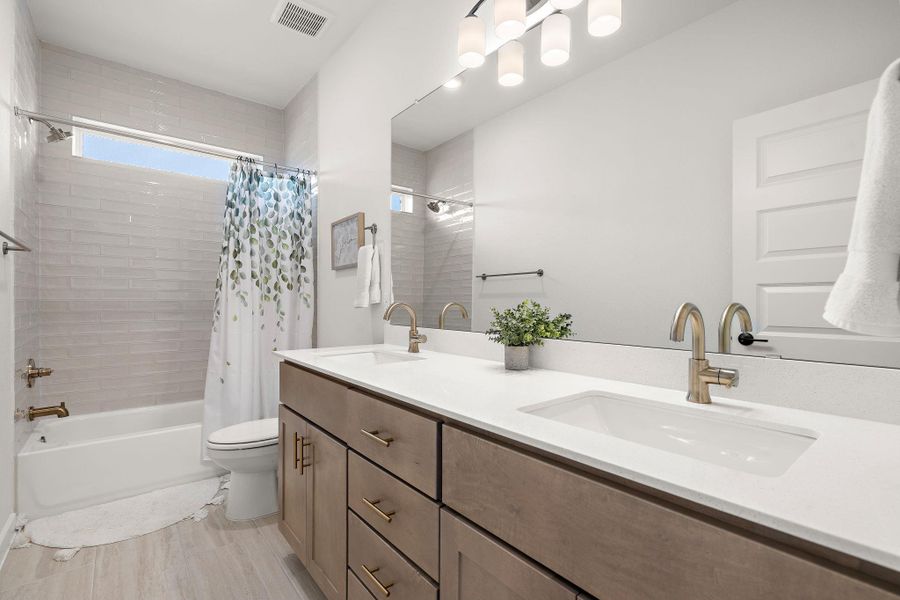 Dual vanity with integrated sinks and brushed gold-tone faucets
