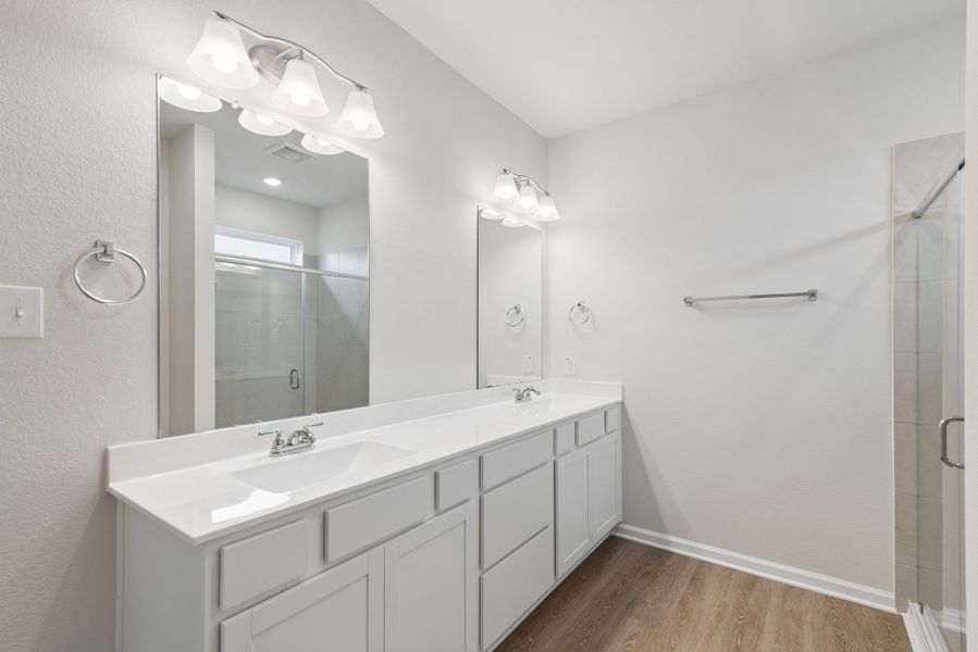 The Oakshire II- Primary Bathroom with Dual Vanities and Walk-In Shower.  Sample image for illustration; upgrades, options, and colors may vary.