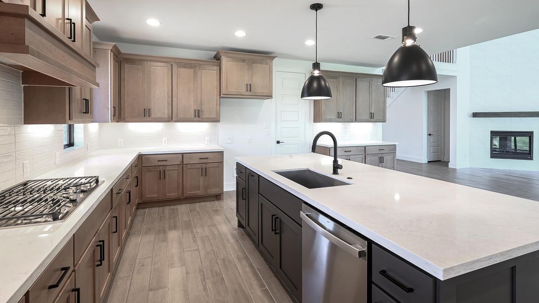Kitchen featuring light wood-type flooring, a kitchen island with sink, light stone countertops, appliances with stainless steel finishes, and recessed lighting Kitchen featuring light wood-type flooring, a kitchen island with sink, light stone countertops, appliances with stainless steel finishes, and recessed lighting