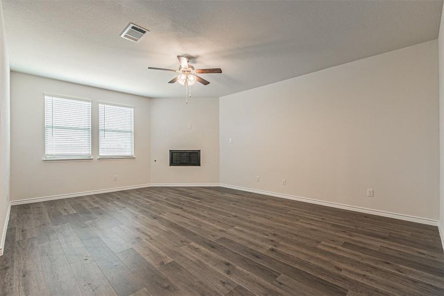 Unfurnished living room with ceiling fan and hardwood / wood-style floors