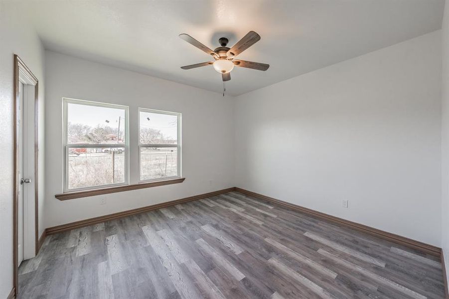 Empty room with ceiling fan, baseboards, and wood finished floors