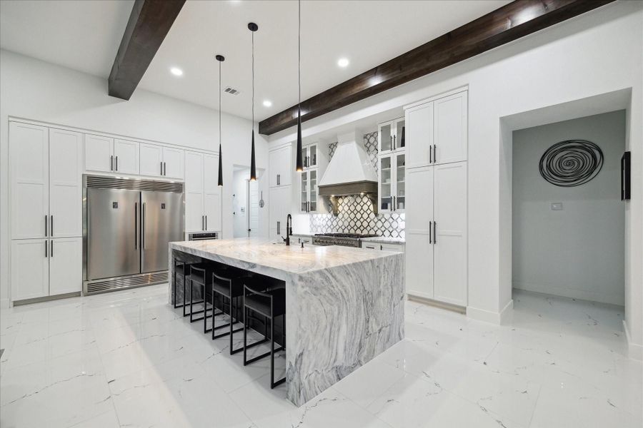 Large, modern Kitchen draped in whites and grays that is also warmed up with the continuous wood beams Large, modern Kitchen draped in whites and grays that is also warmed up with the continuous wood beams