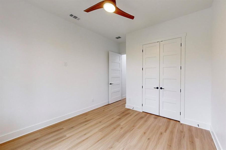 Unfurnished bedroom with a closet, light wood-type flooring, and ceiling fan