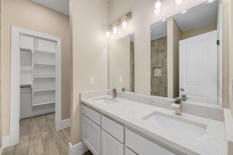 Bathroom featuring wood-type flooring, vanity, and a shower with door