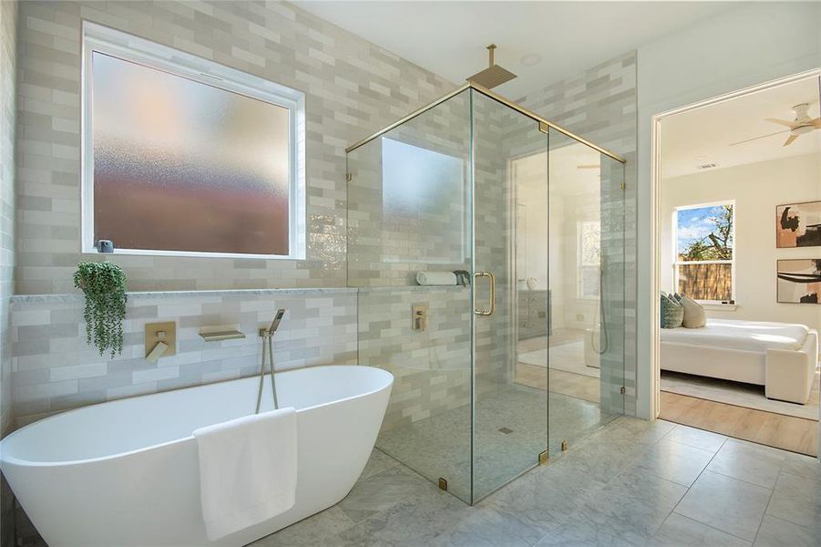 Ensuite bathroom with a freestanding bath, a shower stall, and tile walls Ensuite bathroom with a freestanding bath, a shower stall, and tile walls