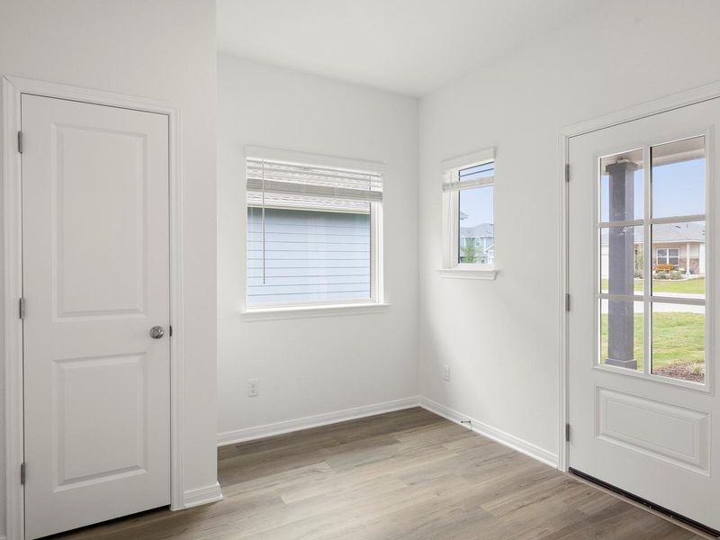 A welcoming entry space with durable wood-look flooring and multiple windows for abundant light.