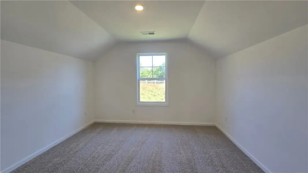 Angled ceilings and soft carpeting create a cozy a