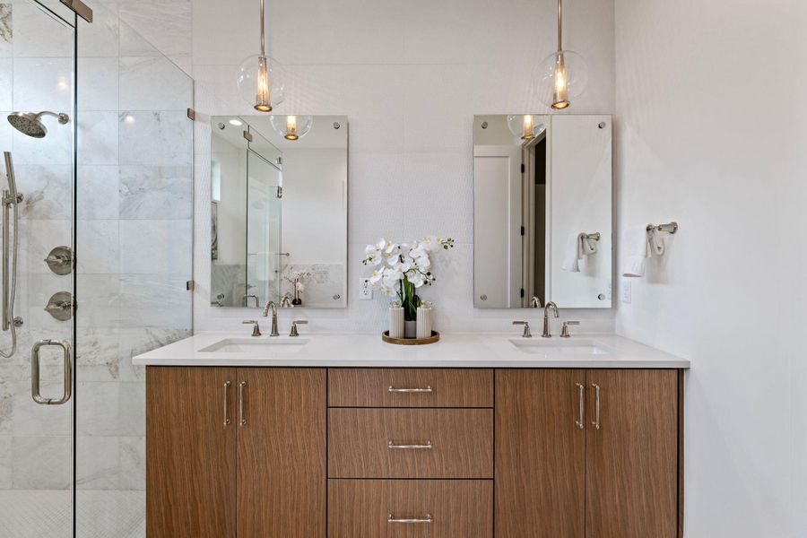 Bathroom featuring double vanity and a shower stall