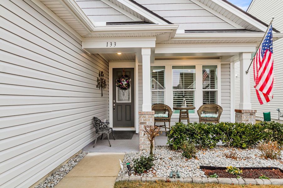 Exterior details and patio area of a home in K. Hovnanian's® Four Seasons at Lakes of Cane Bay, Summerville (Image 25).
